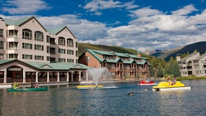Un hotel sul lago con diversi edifici, una fontana e barche sull'acqua.