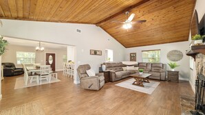 A spacious living room with a wooden ceiling, a ceiling fan, a fireplace, and a dining area with a table and chairs. - 3/2 NEWLY REMODELED HOME IN CRYSTAL RIVER! Bring your boat and RV/Camper!  (Crystal River)