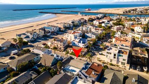An aerial view of a coastal town with houses, a beach, and a pier. - 116S Stranded at the Beach (Oxnard)