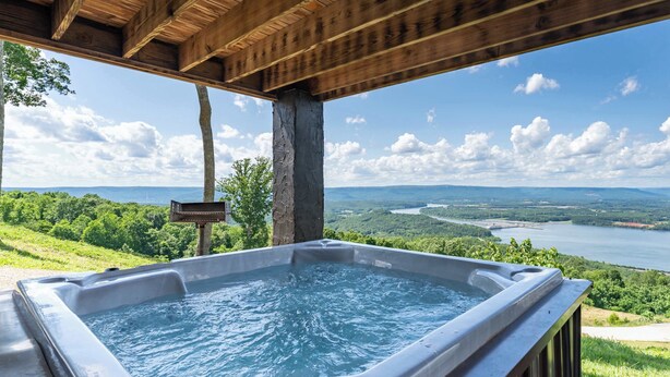 A hot tub with a view of a lake and mountains. - Sunset Ridge cabin 21 miles from Chatt, TN! Indoor pool & hot tub! (Bryant)