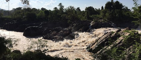 Un río con una cascada rodeada de abundante vegetación.