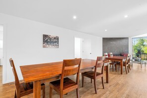 A spacious dining area with a long wooden table and chairs, a blackboard wall, and a view of greenery outside. - Lakefront Paradise: Views, Heated Pool, Games! Summer & Winter Fun For Everyone! (Monticello)