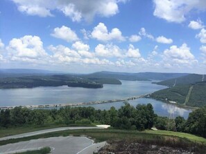 Panoramic coastal views of rolling hills and lush greenery, connected by a scenic bridge.