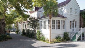A white building with a porch and a staircase. - Casa Zoë | Elegant 3BR Retreat Near King Street (Charleston)
