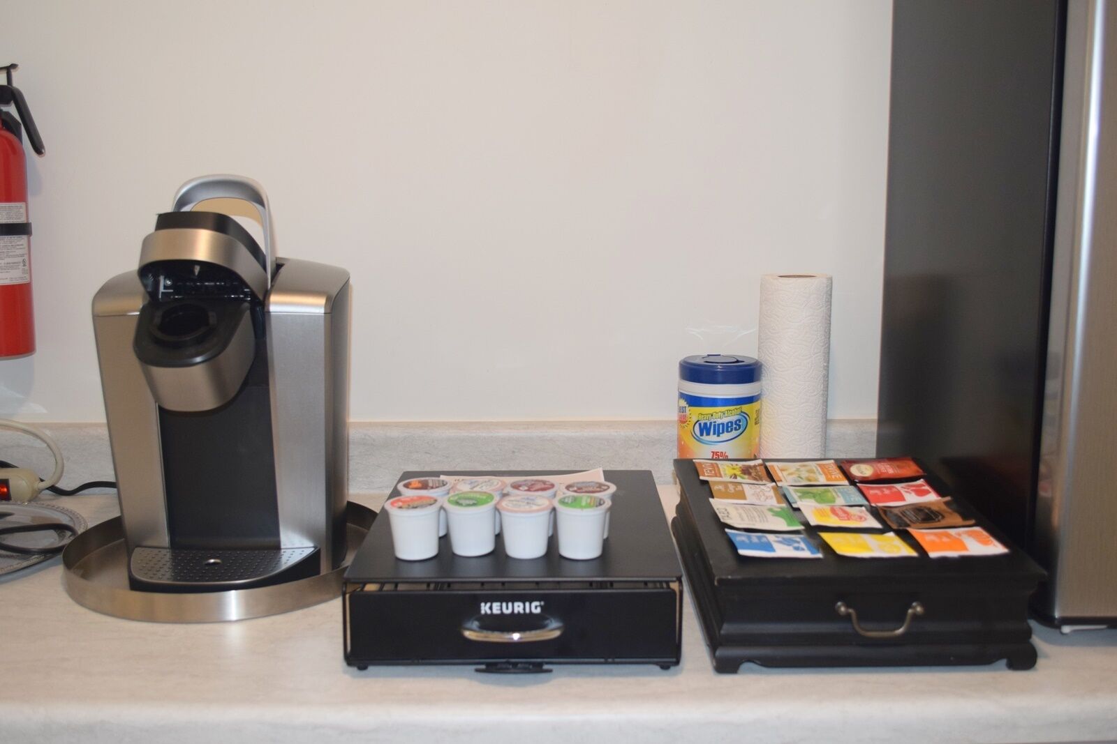 Eine Kaffeemaschine, eine Keurig-Kaffeemaschine und eine Auswahl an Kaffeekapseln auf einer Arbeitsfläche.