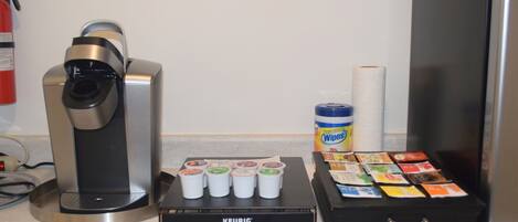 Eine Kaffeemaschine, eine Keurig-Kaffeemaschine und eine Auswahl an Kaffeekapseln auf einer Arbeitsfläche.