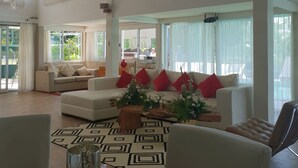 Un espacio habitable amplio con techo alto, ventanas grandes y ventilador de techo.
