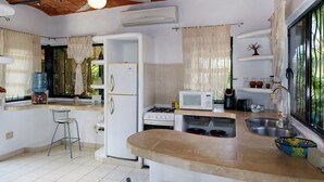 A kitchen with a central island, a refrigerator, a microwave, a stove, and a sink.