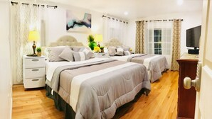A hotel room with two beds, a television, a desk, and a window with curtains. - 4BR 6BEDS WOLLASTON BEACH. NearBOSTON3 (Quincy)