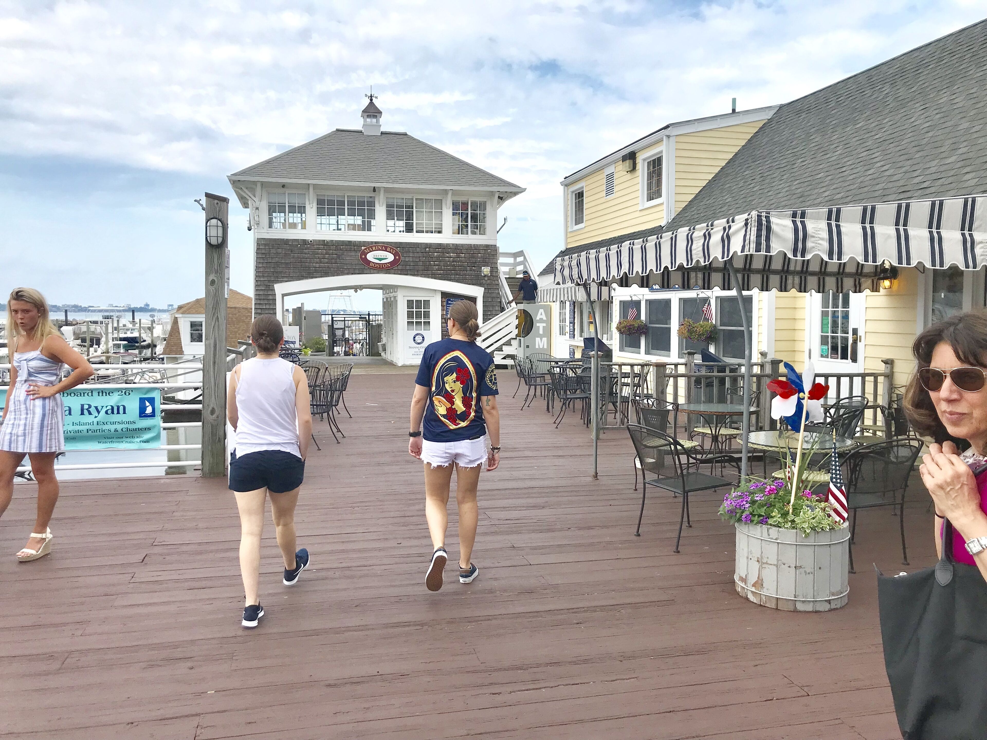 A wooden boardwalk with outdoor seating and a view of the water.