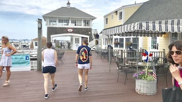 A wooden boardwalk with outdoor seating and a view of the water.