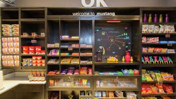 A store interior with shelves stocked with snacks, beverages, and other items.