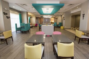 A hotel lobby with a central island, seating arrangements, and a reception area.