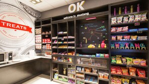 Zona de exhibición de snacks con diferentes productos envasados y una pizarra con indicaciones.
