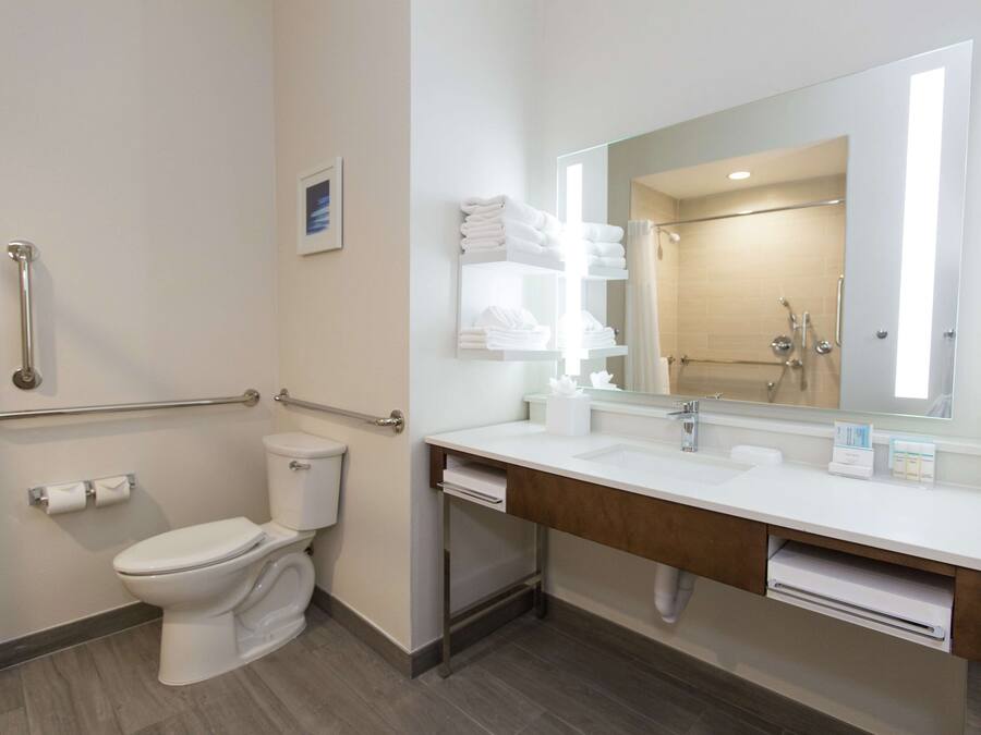 Un baño moderno con inodoro, bidé y lavabo con espejo.