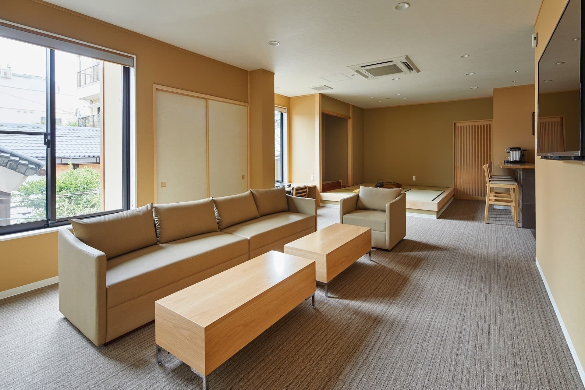 A modern living room with a sofa set, a coffee table, and a dining area with a table and chairs.