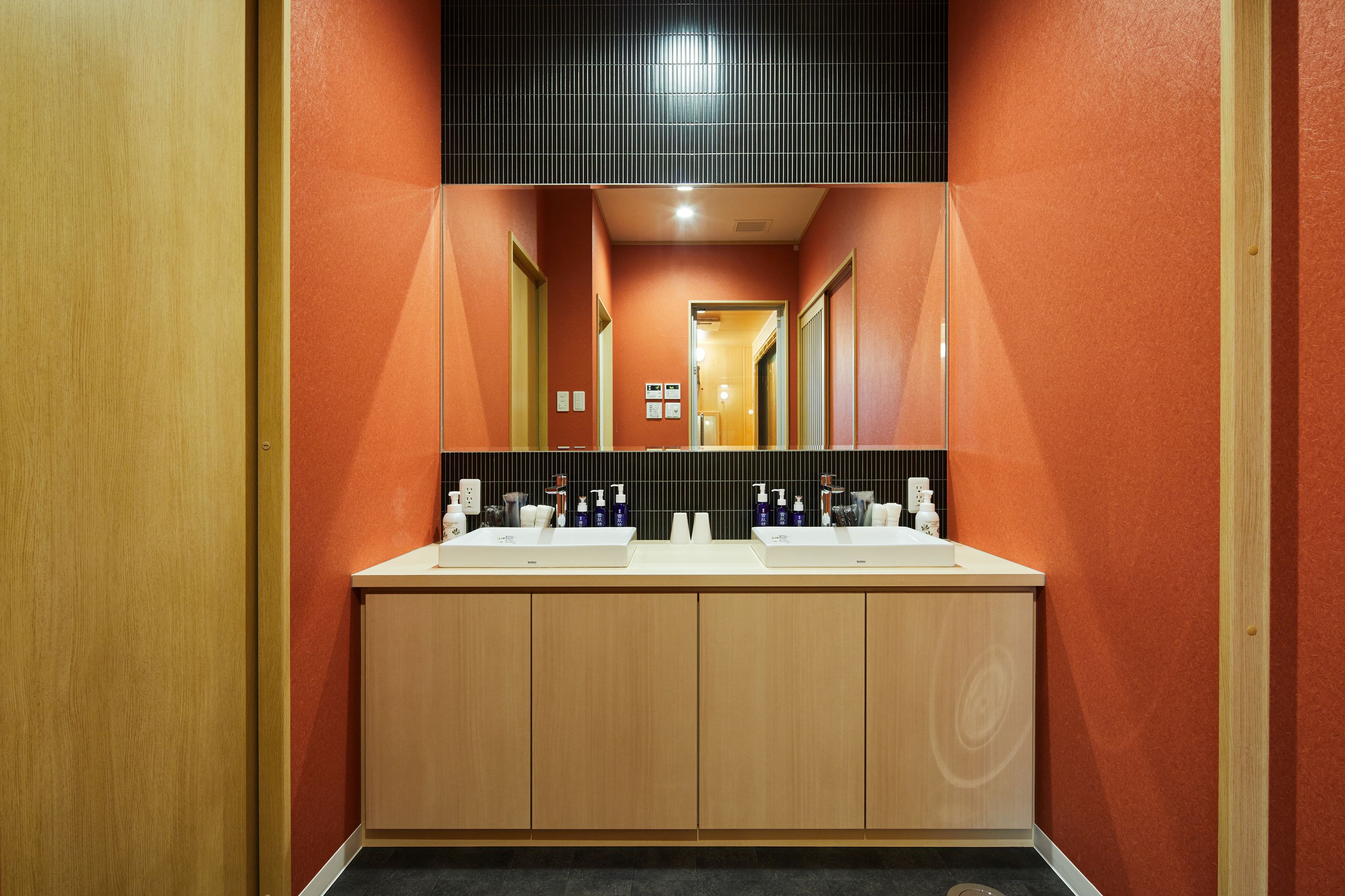 Une salle de bain moderne avec deux lavabos, des meubles en bois et un miroir au-dessus.