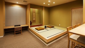 A traditional Japanese-style bedroom with tatami flooring, a low wooden bed, a desk, and a sliding shoji screen. - Onsen No Yado Gion Maisen Bettei (Kyoto)
