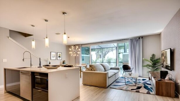 Eine moderne Küche mit einer zentralen Kochinsel, einem Essbereich mit einer Couch und Stühlen sowie einem großen Fenster, das für natürliches Licht sorgt.