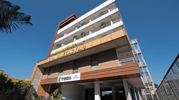 A multi-story building with a prominent sign reading "Grand Legacy Elite". - Treebo Premium Grand Legacy Elite with Roof Top Cafe (Dehradun)