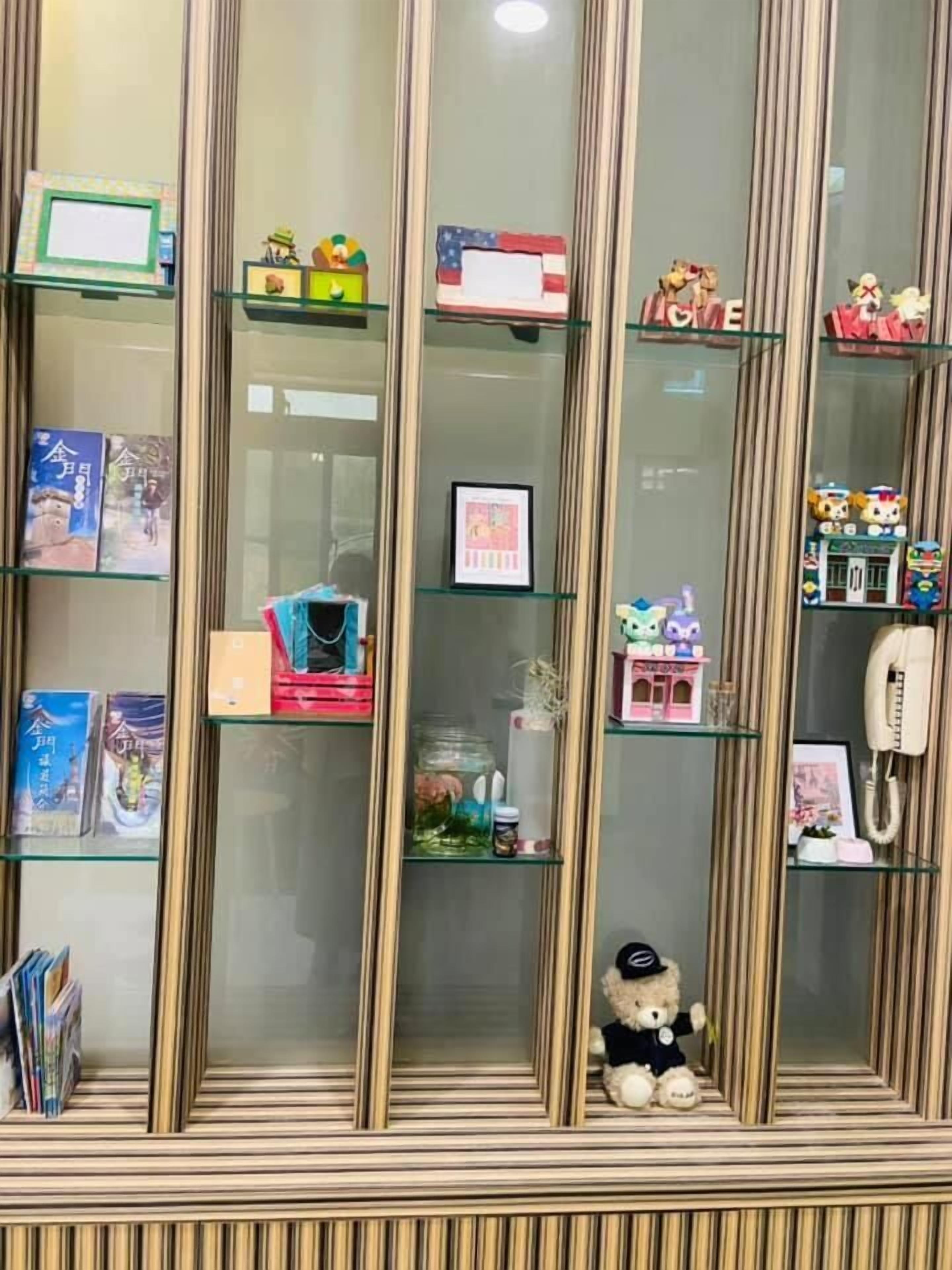 Una habitación con piso a rayas y un expositor de vidrio con varios objetos.
