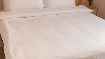 Cubrecamas, espacio para trabajar con laptop y cortinas blackout