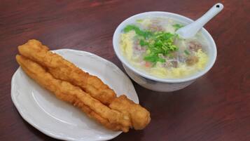A plate with two fried items and a bowl of soup with a spoon.