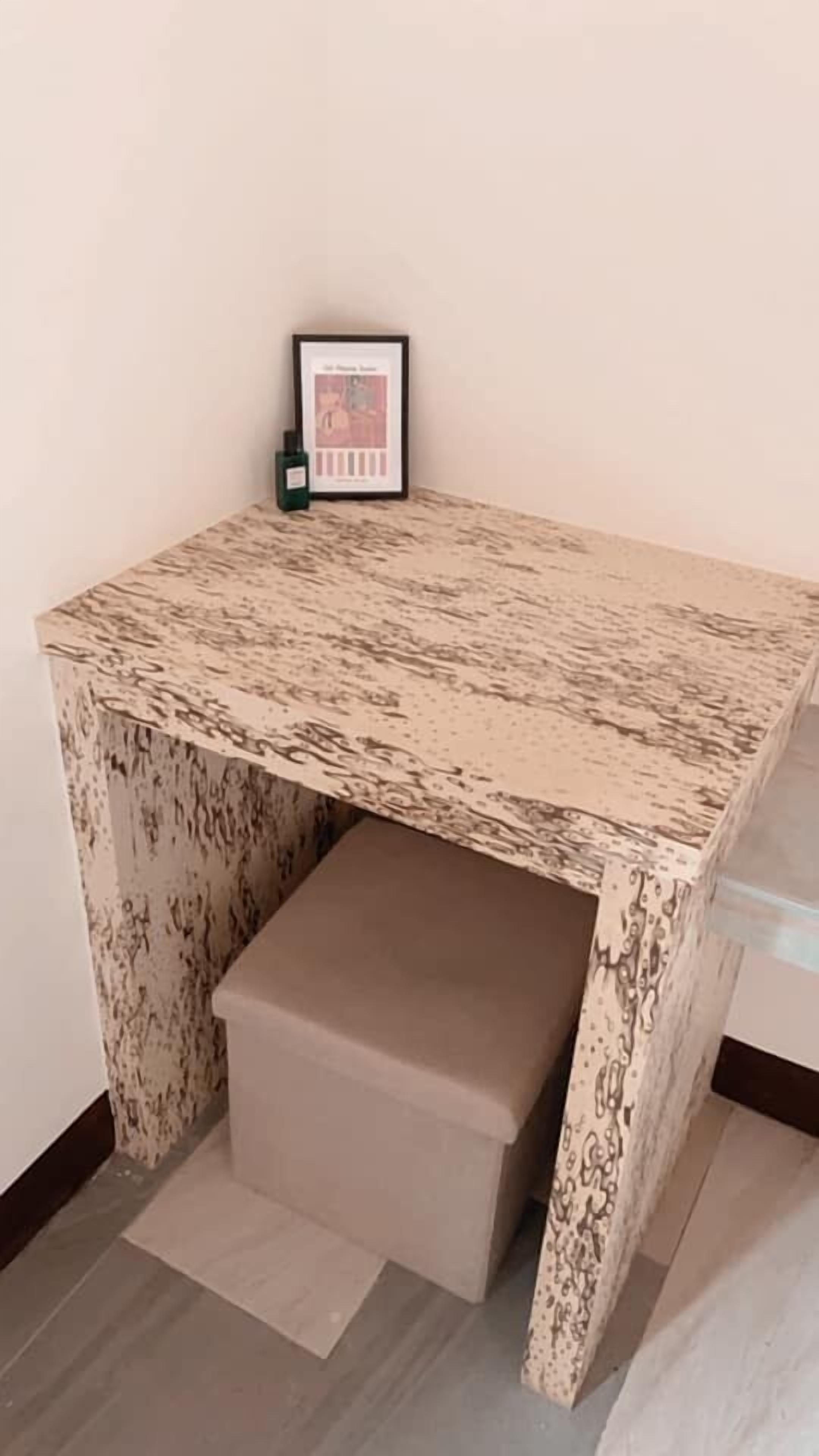 A corner desk with a patterned top and a storage drawer.