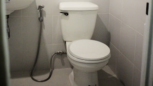 Une petite salle de bain propre, équipée de toilettes, d’un lavabo et d’un porte-serviettes.