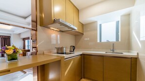 A modern kitchen with a built-in oven, a stainless steel range hood, and a window above the sink. - Zhuhai Boruiwan Binjiang Hotel (Zhuhai)