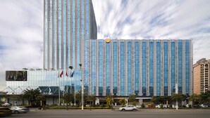 A modern hotel with a tall, rectangular building and a shorter, wider structure in front. - Zhuhai Boruiwan Binjiang Hotel (Zhuhai)