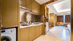 A compact kitchen with a built-in washing machine, a stove, and a sink. - Zhuhai Boruiwan Binjiang Hotel (Zhuhai)