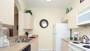 A modern kitchen with a dishwasher, sink, refrigerator, stove, and a clock on the wall. - Ov3718 - Windsor Palms Resort - 3 Bed 2 Baths Townhome (Kissimmee)