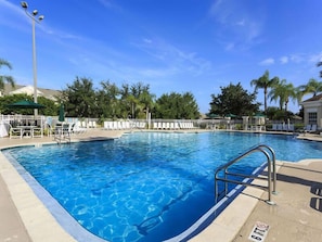 A clear blue swimming pool with a metal ladder, surrounded by white lounge chairs and umbrellas, with palm trees and a clear sky in the background. - Ov3718 - Windsor Palms Resort - 3 Bed 2 Baths Townhome (Kissimmee)