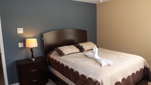 A neatly made bed with a brown headboard, a lamp on a bedside table, and a wall switch. - Ov3688 - Compass Bay - 4 Bed 2.5 Baths Townhome (Kissimmee)