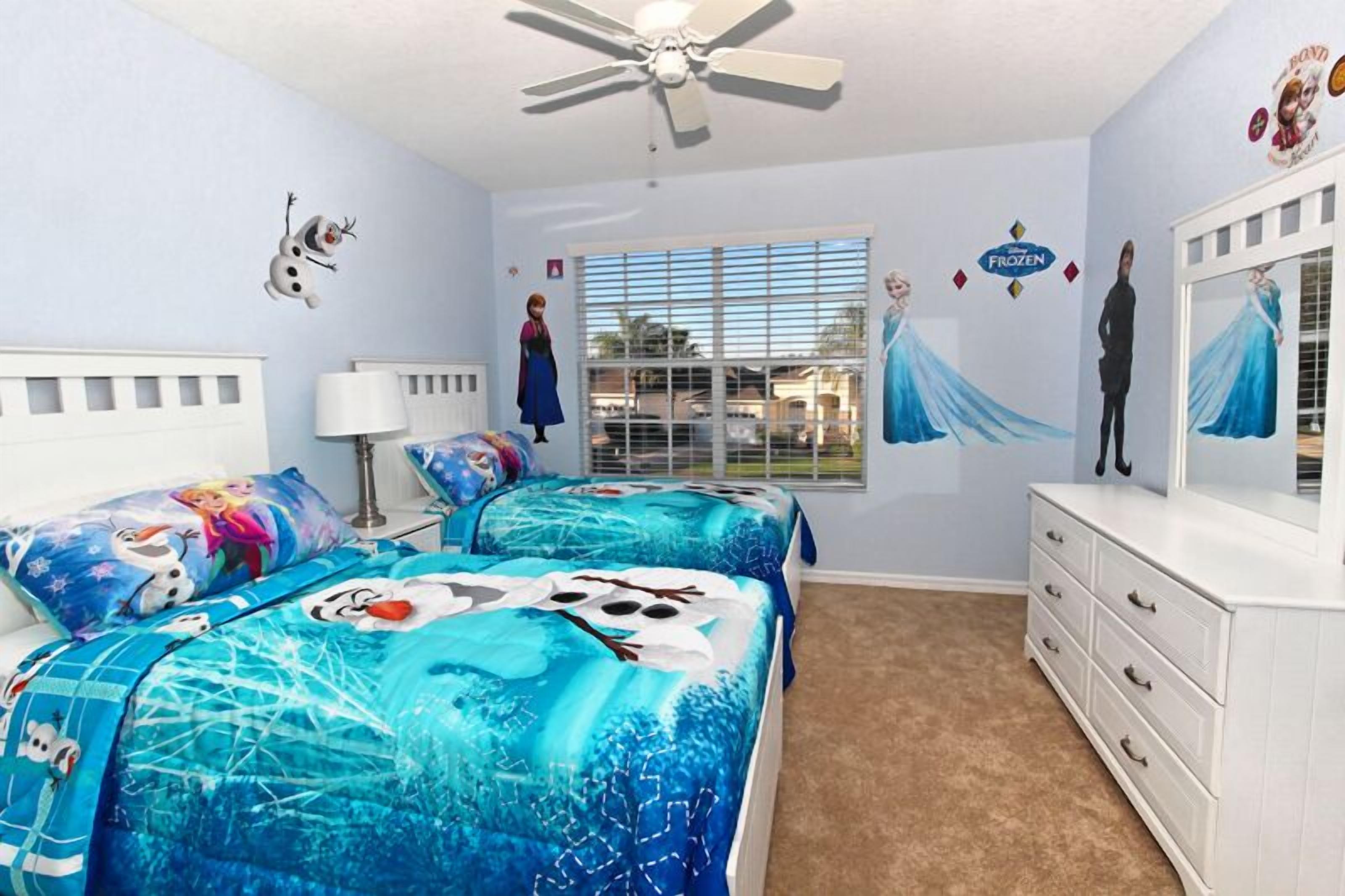 A bedroom with two beds, a ceiling fan, a dresser, and a window with blinds.