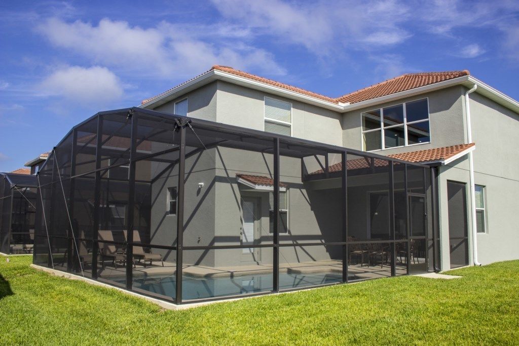 A modern house with a large glass-enclosed patio area.