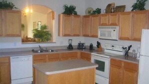 A kitchen with wooden cabinets, a microwave, a stove, and a dishwasher.