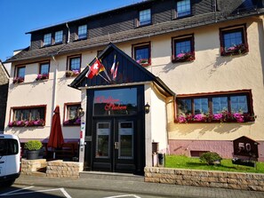 A building with a sign reading "Wattliser Stuben" and multiple flower boxes on the windowsills. - Hotel Thielmann (Mittenaar)