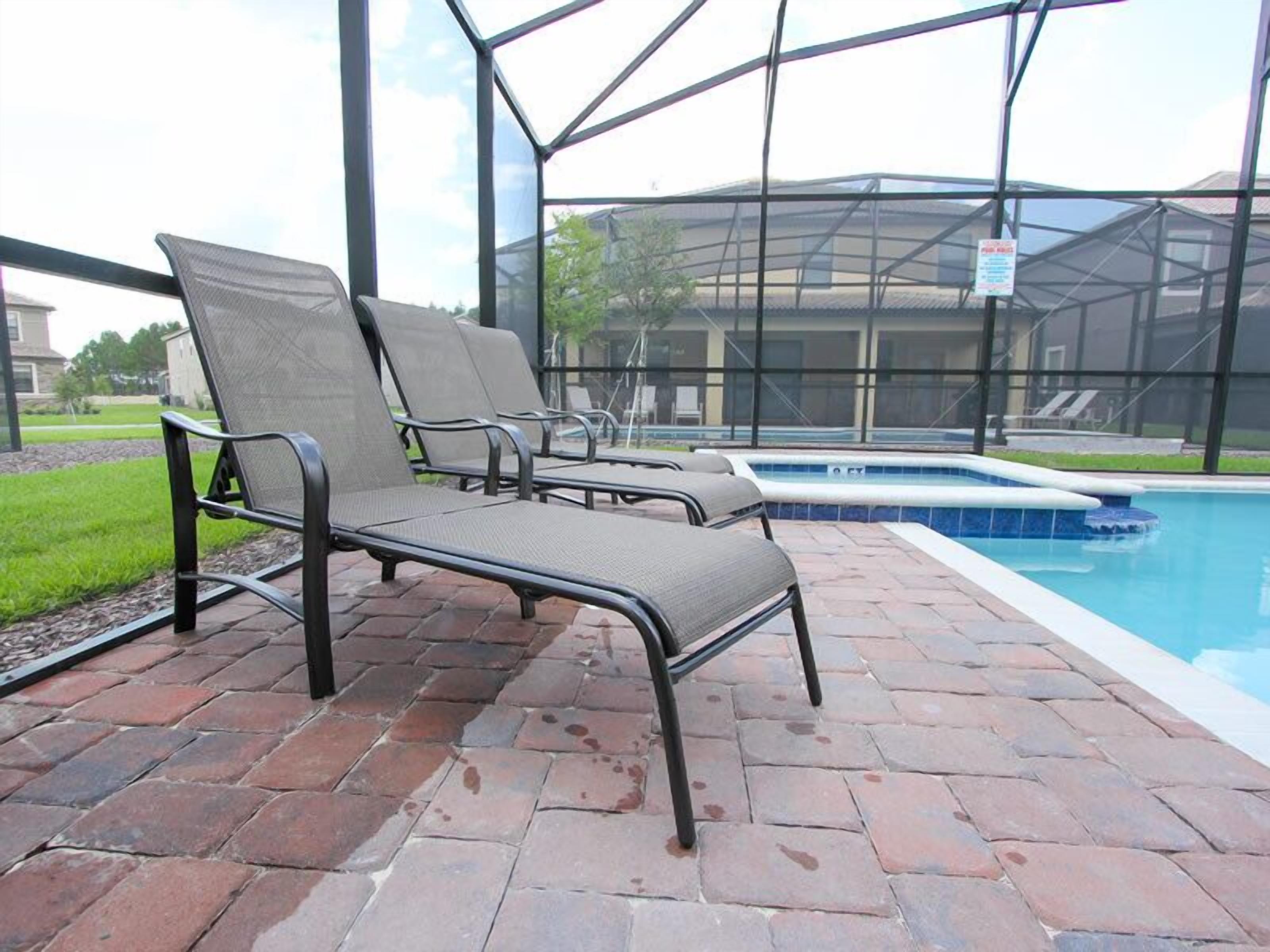 A poolside area with metal chairs and a swimming pool.