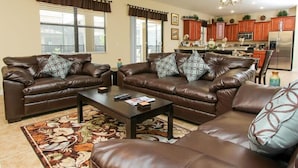A living room with two brown leather sofas, a coffee table, and a patterned rug. - Ov3238 - Champions Gate Resort - 6 Bed 6 Baths Villa (Davenport)