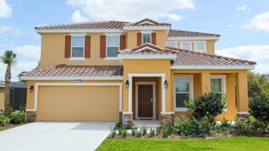 A two-story house with a garage, a front porch, and a well-maintained lawn. - Ov3223 - Solterra Resort - 5 Bed 5 Baths Villa (Davenport)