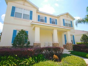 A two-story house with a covered front porch, stone pillars, and a number '1229' on the facade.