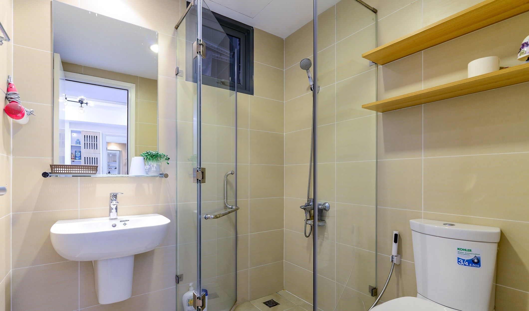 A modern bathroom with a glass-enclosed shower, a white sink, and a toilet.
