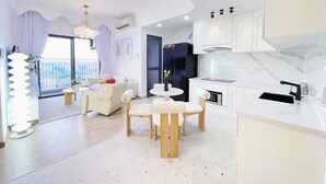 Una sala de estar moderna con comedor, cocina y balcón con vista a la ciudad.