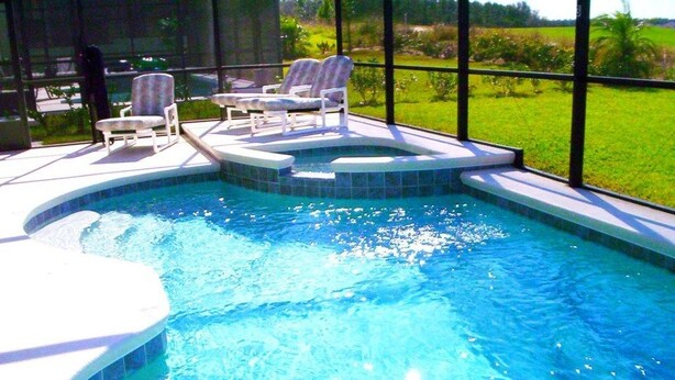 A swimming pool with a hot tub, surrounded by lounge chairs, and a view of a green landscape. - Ov3153 - Highlands Reserve - 5 Bed 3 Baths Villa (Davenport)