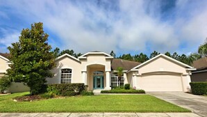 A single-story house with a front entrance, a garage, and a well-maintained lawn.