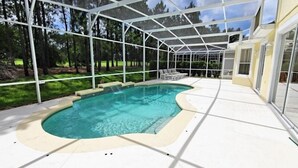A covered outdoor swimming pool with a clear view of the surrounding trees and a patio area with seating. - Ov3141 - Highlands Reserve - 6 Bed 4 Baths Villa (Davenport)
