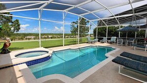 A covered outdoor swimming pool with lounge chairs and a hot tub.