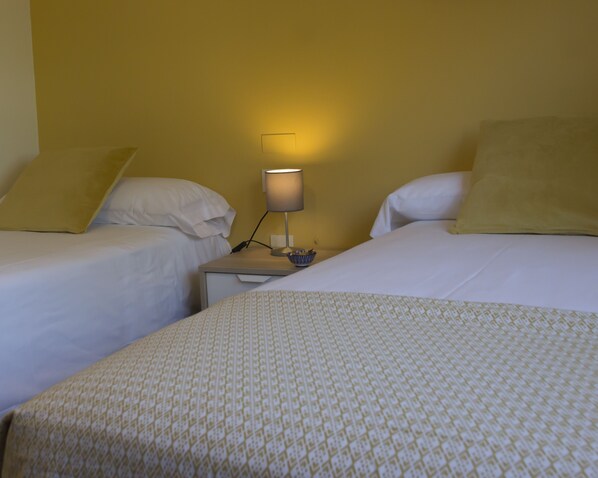 A hotel room with two single beds, a nightstand with a lamp, and a small bowl on the nightstand. - Hotel O Pazo (Vigo)